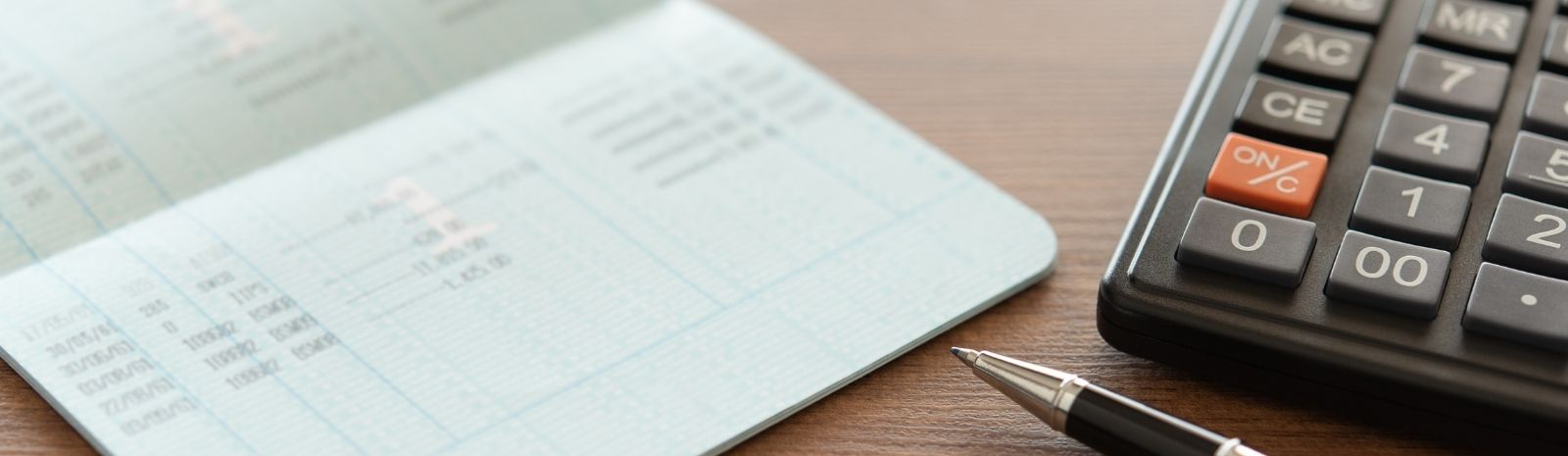 Calculator, pen, and spreadsheet on a desk