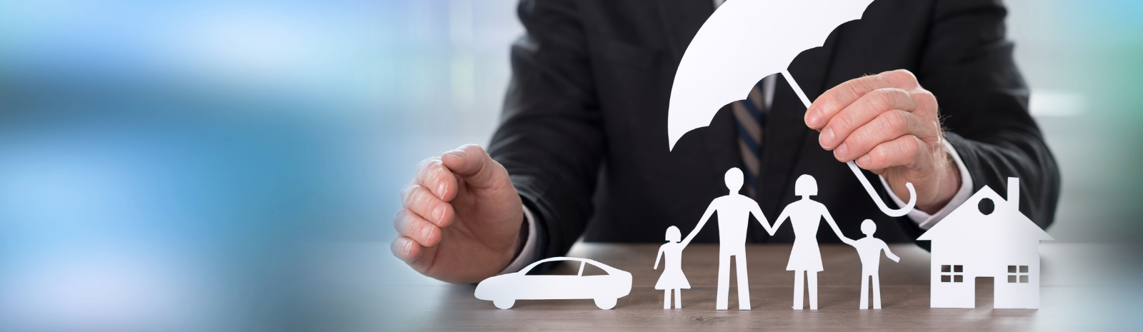 Insurance agent holding an umbrella over a car, family, and home