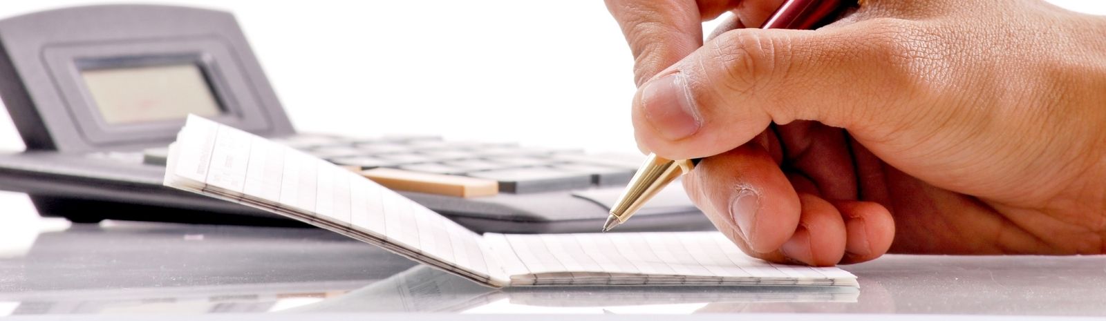 Person crunching numbers using calculator and notepad