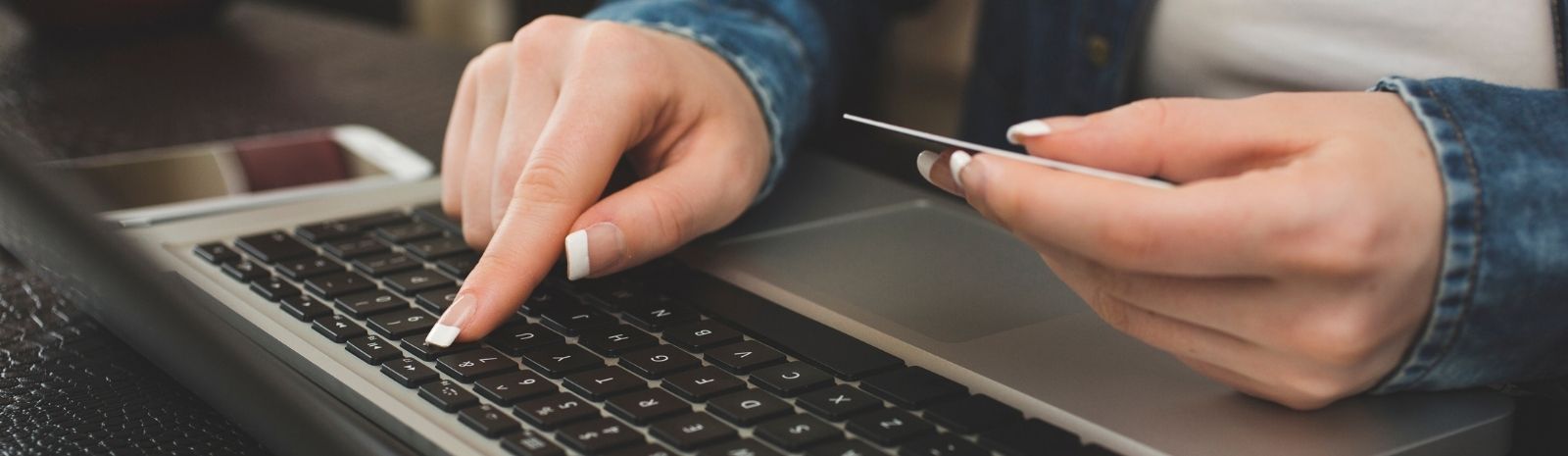 Person typing card number in on a computer